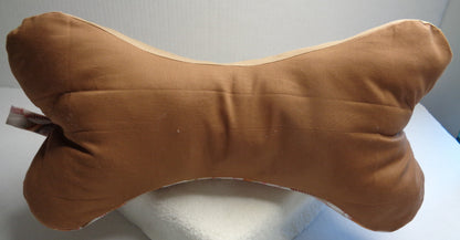 A bone-shaped neck pillow with a medium brown fabric. Side two of the baseball pillow.