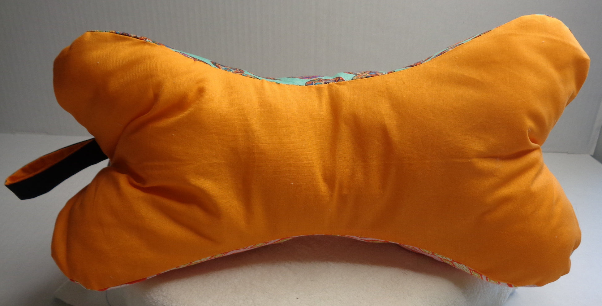 A bone-shaped neck pillow with Orange fabric